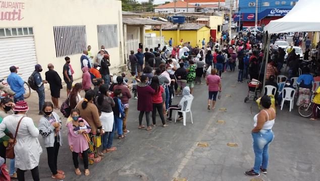 Pessoas fazem fila para ganhar osso de boi em açougue, em Cuiabá | Foto: Rogério Florentino/Yahoo Notícias